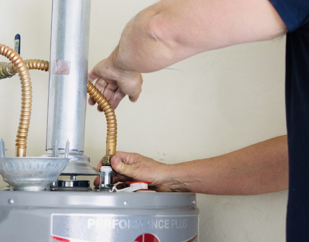 A plumber adjusting a water heater