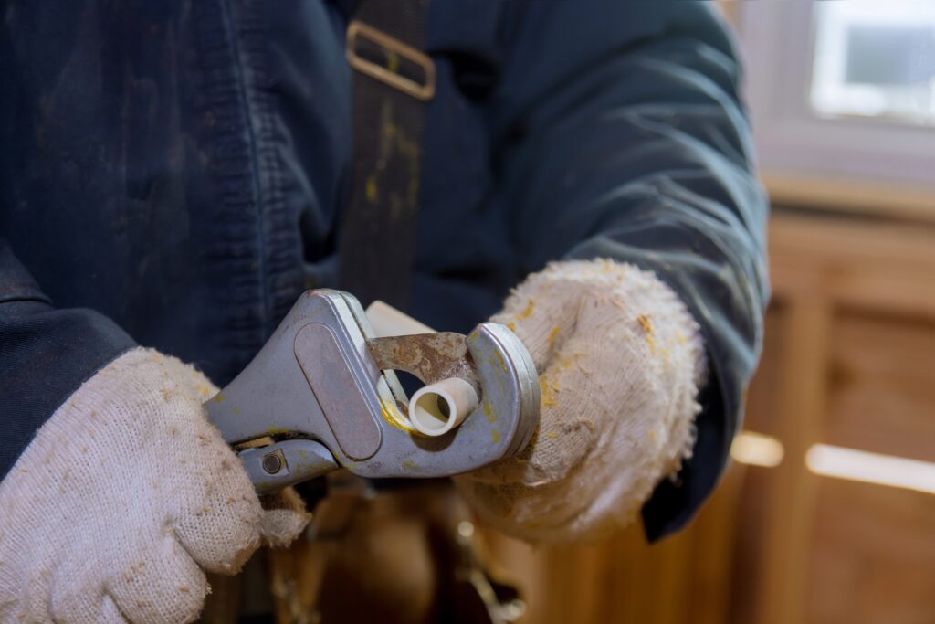 A plumber cutting a piece of pipe